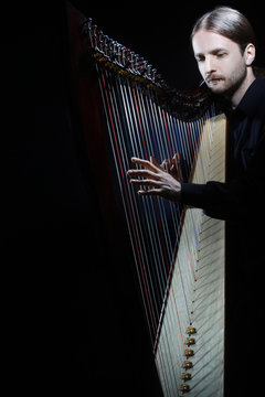 Harp player. Harpist musician playing Irish harp