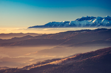 Obraz premium panorama over misty Gorce to snowy Tatra mountains in the morning, Poland landscape