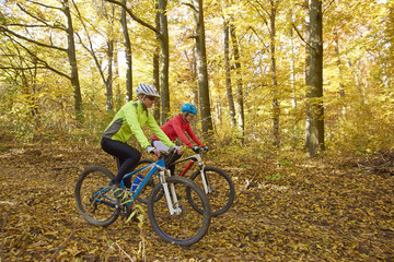 Fototapeta na wymiar On the mountain. Two cyclist woman enjoying the beautiful scenery while out mountain biking.