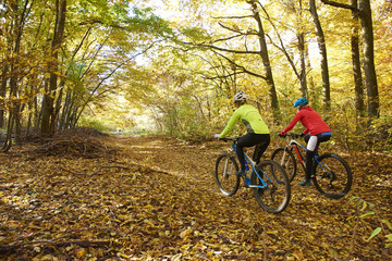 Fototapeta premium On the mountain. Two cyclist woman enjoying the beautiful scenery while out mountain biking.