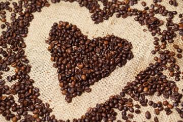 Love heart made of coffee beans on sackcloth