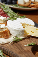 Cheese, vegetables, fruits and spices. Bread, olives and crackers. Mediterranean diet and cuisine. Dark background. Top view.