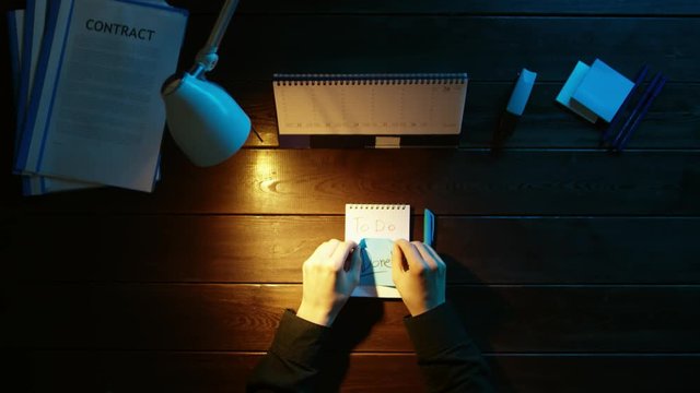 A man is sitting at an office desk and using a phone.
