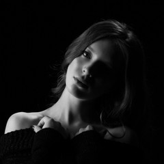 Woman lighted half face, portrait of young light hair model woman posing on black background in studio black and white