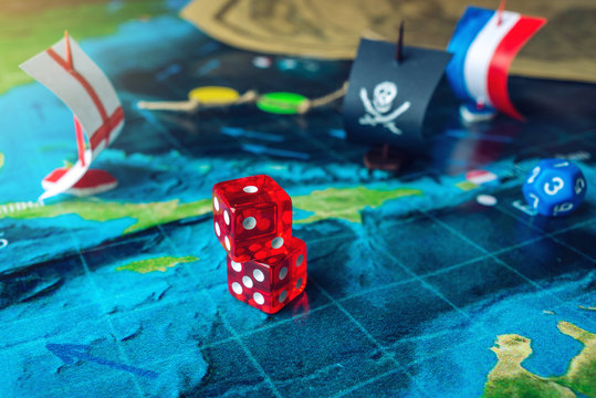 Red playing bones on the world map of the field handmade Board games with a pirate ship