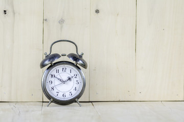 Vintage alarm clock  on wooden floor