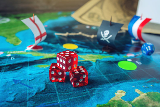 Red playing bones on the world map of the field handmade Board games with a pirate ship