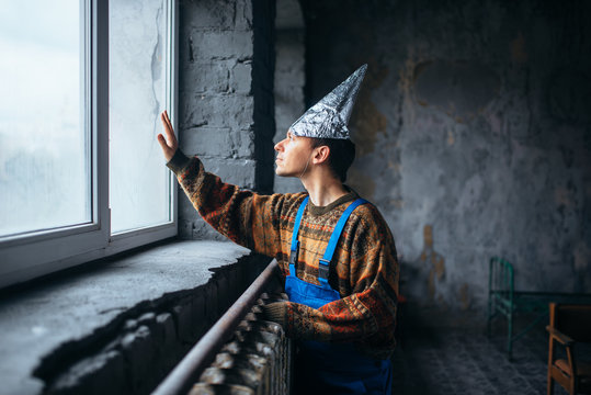 Man in tinfoil cap looking out the window, UFO