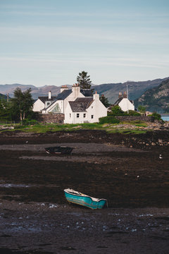 cottages in plockton scotland with the tide out and some rowing boats stranded on the seabed