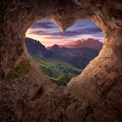 Fotobehang Uitzicht vanaf hartvormige grot naar het idyllische berglandschap © rasica