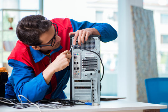 Computer repairman working on repairing computer in IT workshop