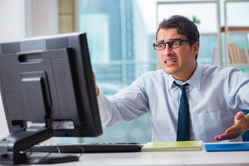 Obraz premium Unhappy businessman sitting at desk in office
