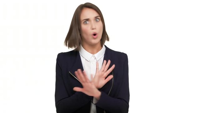 portrait of determined young woman with dark short hair expressing definite rejection feeling disgust don't want to accept gesturing with hands crossed making X shape saying NO over white background