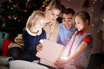 Obraz na płótnie Canvas Happy Family Opening Christmas Present