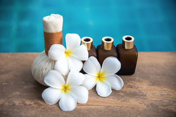 Fototapeta na wymiar Thai Spa composition treatments aroma therapy for relax body with Plumeria flowers near swimming pool. Healthy Concept.