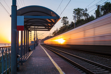 The platform of railway station and train in motion blur at sunset, Sochi, Russia