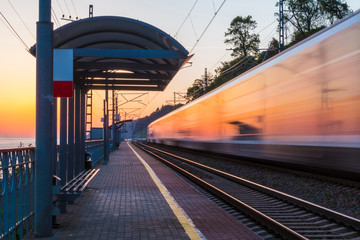 The platform of railway station and train in motion blur at sunset, Sochi, Russia