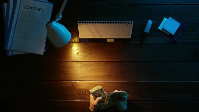 A man is sitting at an office desk and using a phone.