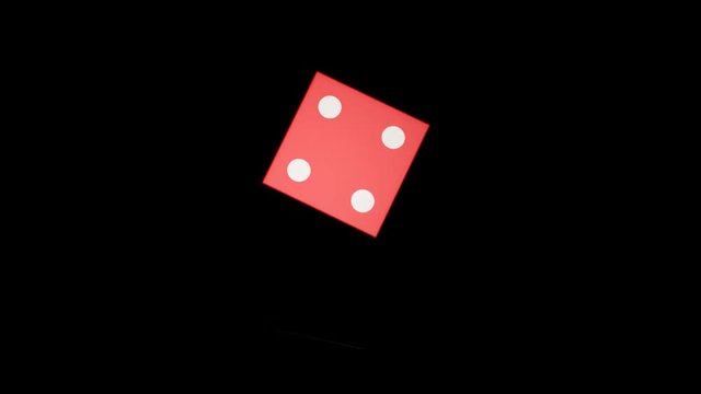 Red dice rotation on black background with reflection on surface