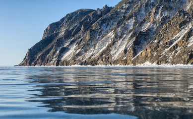 Fototapeta na wymiar Перевести вGoogleBingtransparent ice of lake Baikal and the reflection of the rockstransparent ice of lake Baikal and the reflection of the rocks