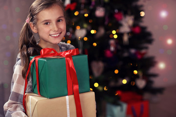 Fototapeta na wymiar Happy girl posing with presents during Christmas time