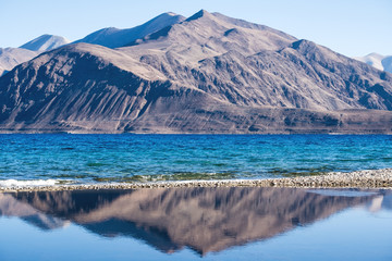 Obraz premium Landscape reflection image of Pangong lake with mountains view and blue sky background