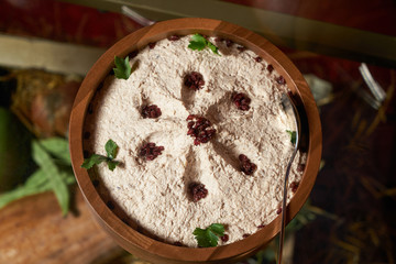 Sour cream with walnut in a wooden bowl