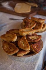 Grandmother bakes pies on the pan and serves to the table