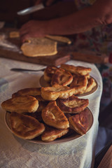 Grandmother bakes pies on the pan and serves to the table