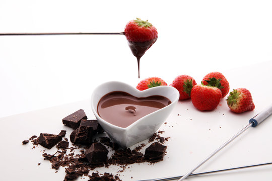 Chocolate fondue melted with fresh strawberries and milk chocolate pieces