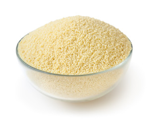 Uncooked couscous in glass bowl isolated on white background with clipping path