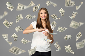 Young woman with money on grey background