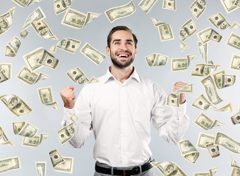Young man with money on grey background