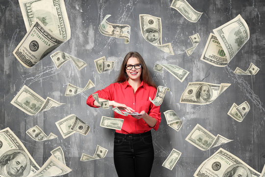 Young woman with money on grey background