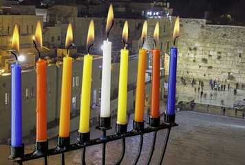 Image of jewish holiday Hanukkah with menorah (traditional candelabra) and burning candles on Jerusalem background.