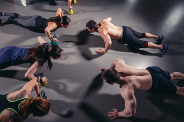 Group adults doing push up exercises indoor
