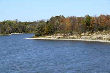 Obraz premium shoreline the Fanshawe reservoir lake lined with with colorful trees in Autumn , in London, Ontario Canada