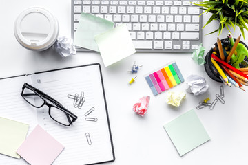 Clutter in office. Desk covered with crumpled paper and scattered stationery. White background top...