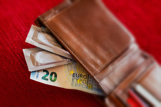 Condoms and banknotes in the leather wallet