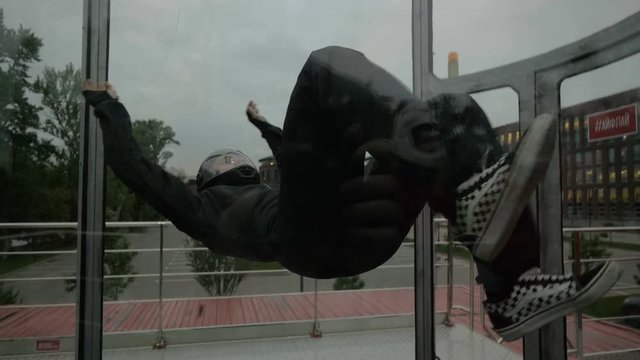 Professional skydiver making acrobatic stunt in wind tunnel. Extreme parachuting
