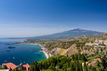 Taormina bay on a summer day with the Etna volcano in the background seen from the Greek theater of Taormina, Sicily, Italy