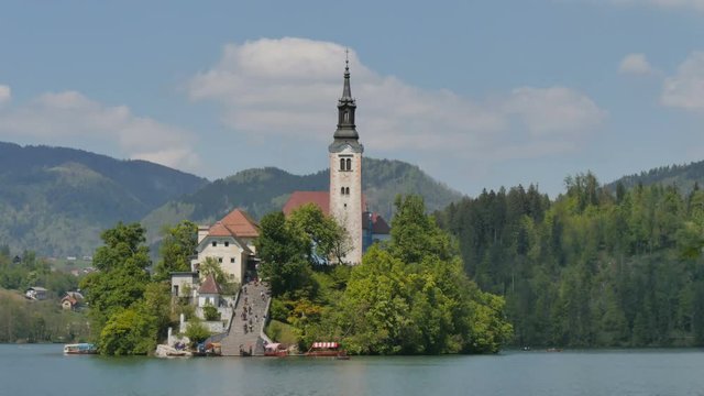 Famous Church on the Island of Bled Lake in Slovenia Alps 4K UHD Timelapse. Bled lake castle and island is an Iconic Slovenia Touristic place with terme and hotel where Tourists rowing and boating.