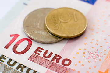 Hungarian Forint coins sit on top of Euro banknotes