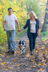 Closeup front view view of a couple walking through an autumn park