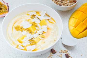 Mango smoothie bowl with coconut, granola and passion fruit.