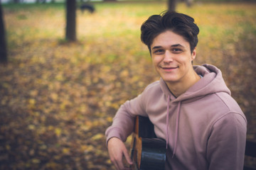 Young Male Guitarist In the Park