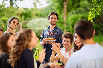 a group of students celebrating a friend's birthday outside