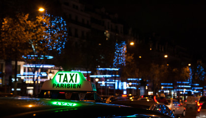 A Parisian taxi for hire at Avenue des Champs-Elysees decorated Christmas illumination.