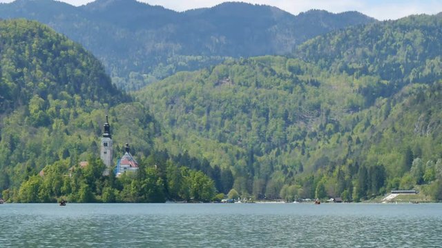 Bled Lake Island with Church. Hyperlapse in 4K UHD. Bled lake its castle and island with church is a Slovenia iconic place with terme and hotel. Tourists can rowing, boating and camping in the Alps