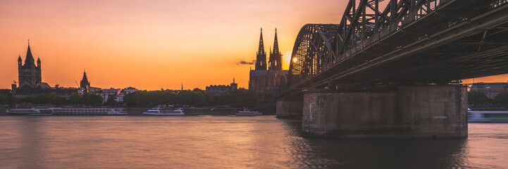 Sonnenuntergang in Köln am Rhein neben der Hohenzollernbrücke mit Blick auf den Dom